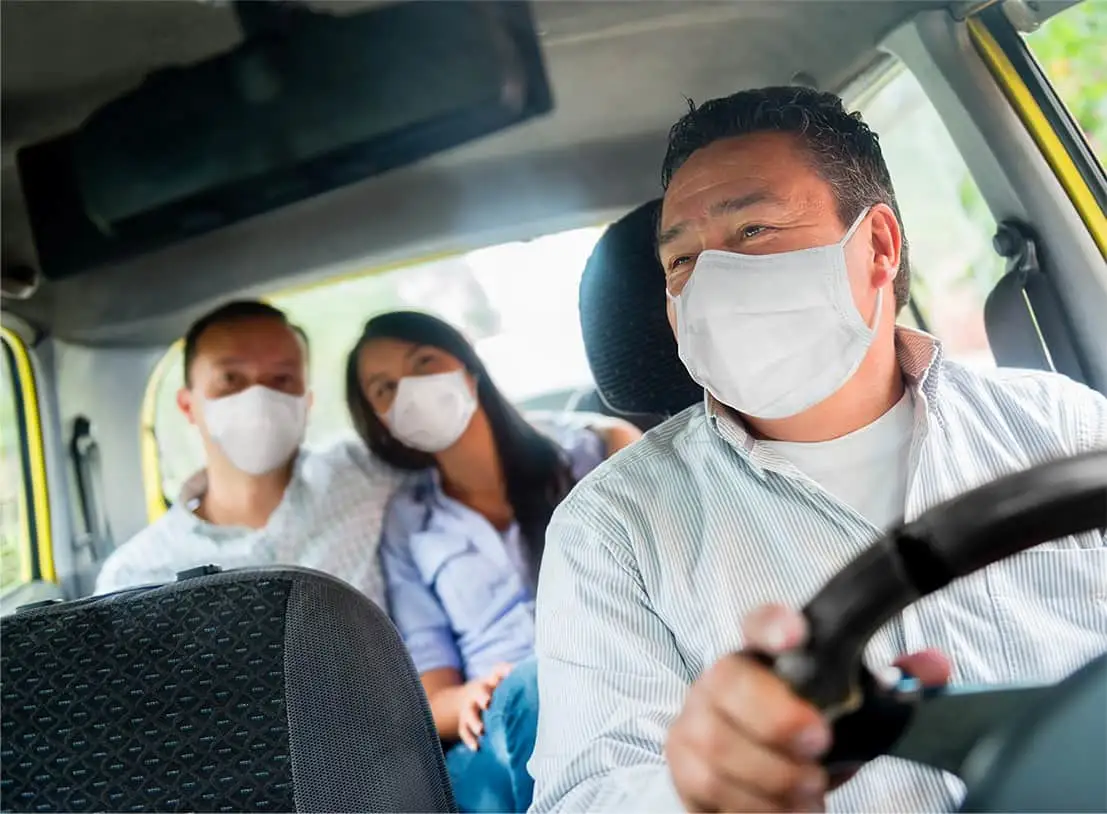 Bus driver and passenger wearing face mask looking forward