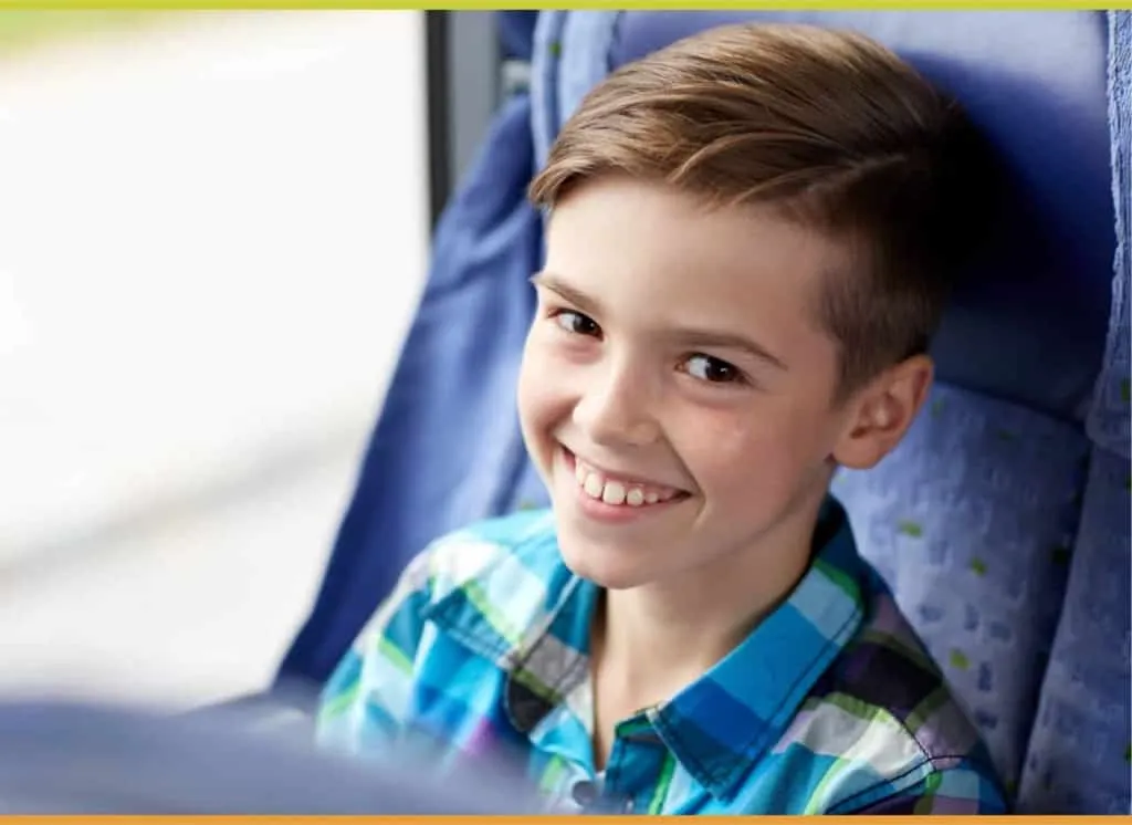 Young boy smiling while riding the bus